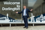 Peter Gibson in front of "Welcome to Darlington" sign